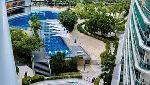 A view of a high-rise building with a swimming pool and surrounding greenery. - Azure Urban Resort 1BR-2BR Boracay (Parañaque)