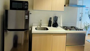 Eine moderne Küche mit Edelstahlgeräten, Holzschränken und einer weißen Arbeitsplatte.