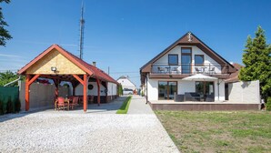 Ein zweistöckiges Haus mit überdachter Terrasse und Balkon.