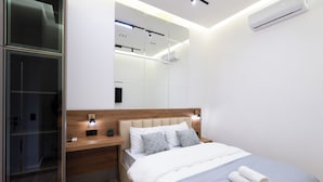 A modern bedroom with a bed, bedside tables, a mirror, and an air conditioning unit. - Boutique 4BR House - Tbilisi Old Town (Tbilisi)