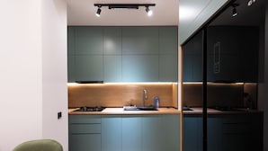 A modern kitchen with teal cabinets, a wooden countertop, and a built-in stove. - Boutique 4BR House - Tbilisi Old Town (Tbilisi)