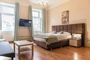 Una camera da letto con un letto grande, comodini e una TV montata a parete.