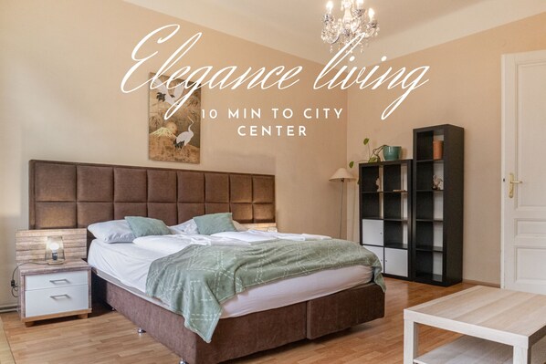 Una camera da letto con un letto grande, un comodino, una libreria e un lampadario.