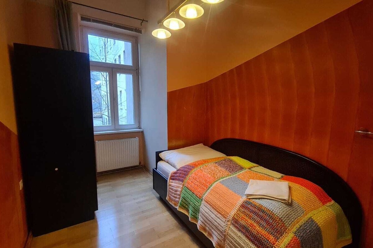 A bedroom with a bed, a window, and a radiator.