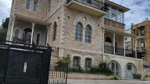 Ένα κτίριο από πέτρα με τοξωτά παράθυρα και μπαλκόνι.