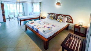 Een slaapkamer met een hemelbed, een nachtkastje met een lamp en een stoel.