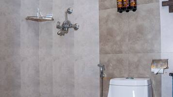 Une salle de bain avec douche, toilettes et une étagère contenant des articles de toilette.
