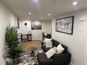 Uma sala de estar moderna com um sofá, uma mesa de centro e uma grande planta em vaso.