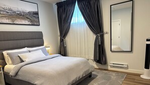 A modern bedroom with a large bed, a nightstand, a bedside lamp, a large mirror, and a painting on the wall. - Fivestar Inspired Private Suite- Downtown Access (Calgary)