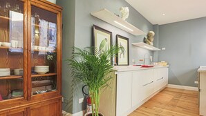 Una cucina moderna con mobili in legno, un'isola centrale e una pianta in vaso.
