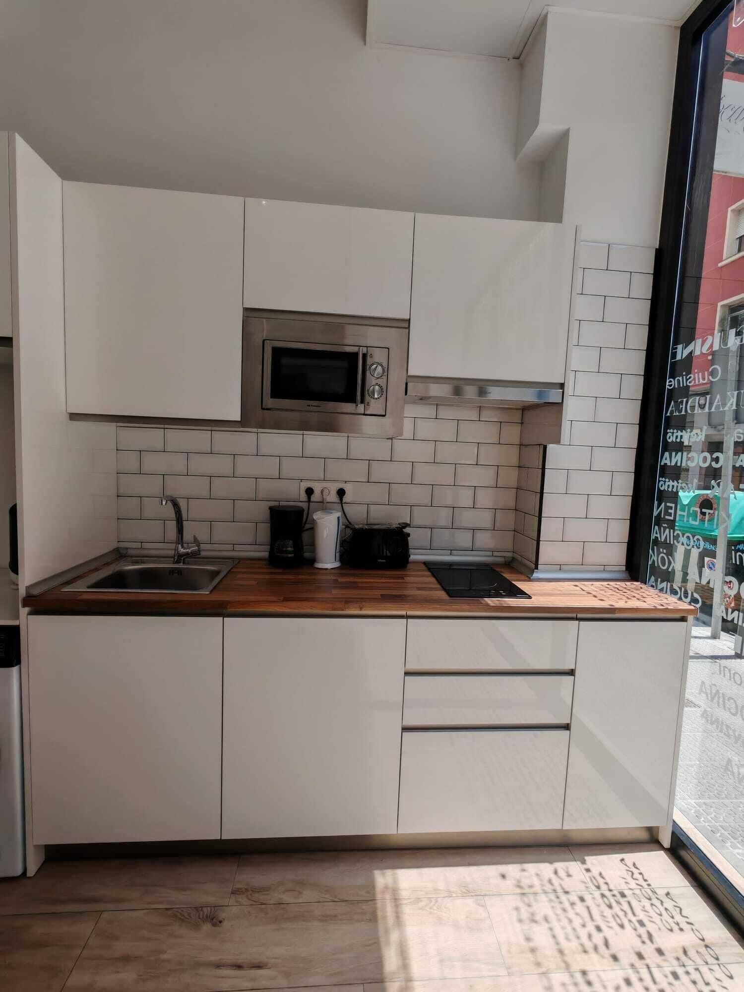 Frigorífico pequeño, microondas, placa de cocina y utensilios de cocina