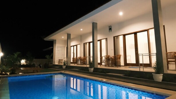 A modern house with a swimming pool and outdoor seating area. - Clean & Affordable Homestay in South Kuta. Simple, Cozy, and Convenient (Badung)
