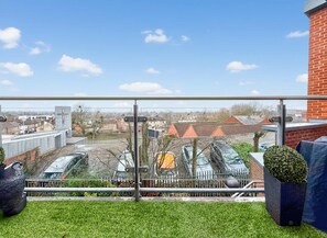 Un balcon offrant une vue dégagée sur le paysage urbain, avec des bâtiments et un chantier de construction.