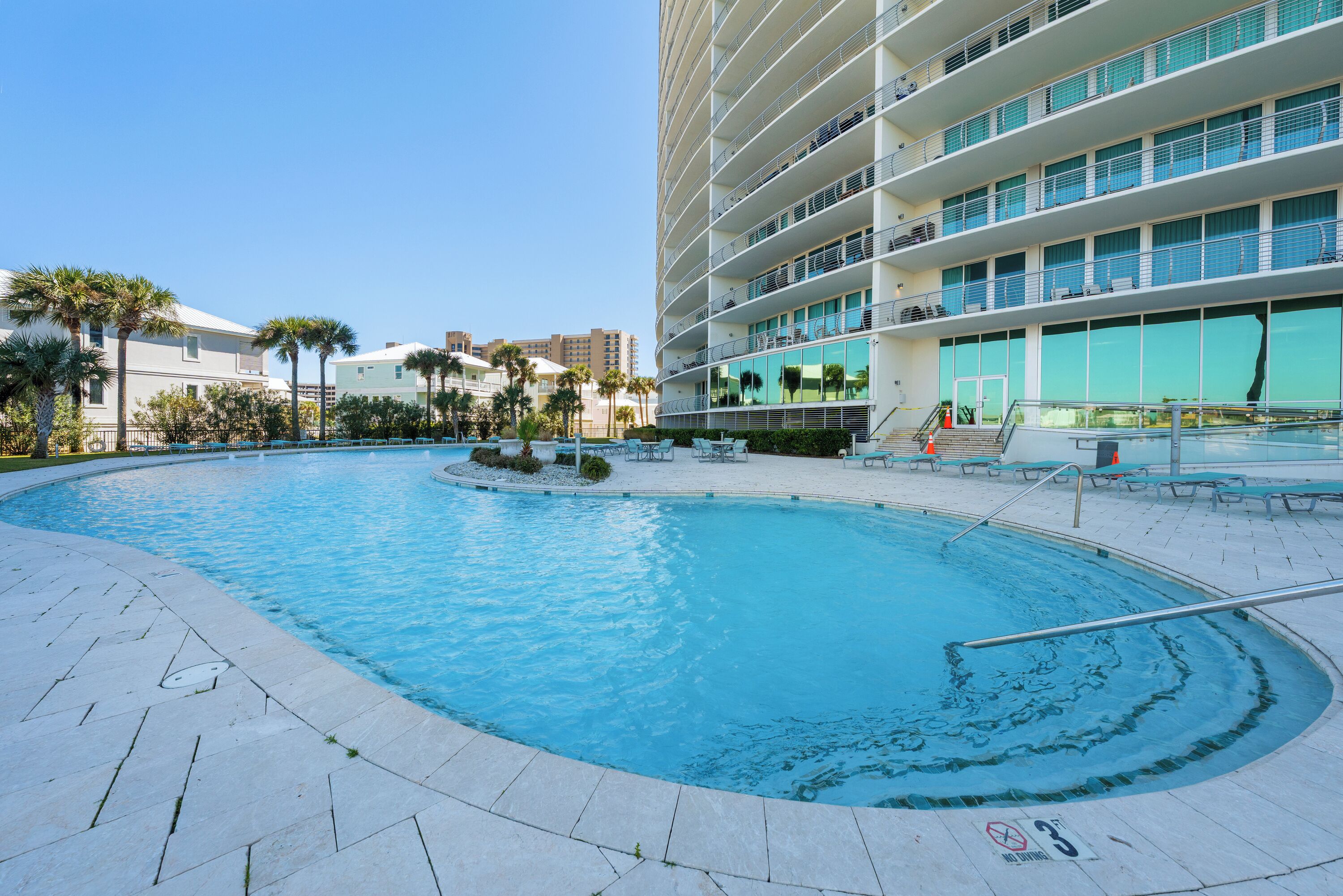 A swimming pool with a circular design, surrounded by a tiled deck.