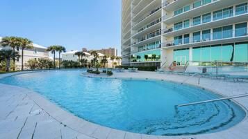 A swimming pool with a circular design, surrounded by a tiled deck.