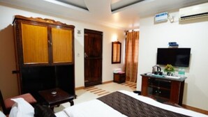 Une chambre d’hôtel équipée d’un lit, d’un bureau, d’une télévision et d’une armoire.