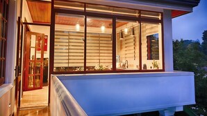 A modern house with a large glass window, wooden shutters, and a balcony. - Cozy 2-bedroom apartment in serene Kandy with AC (Kandy)