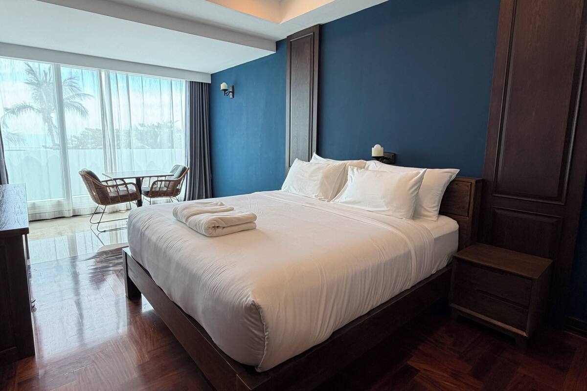 Habitación de hotel con una cama grande, un escritorio con sillas y vistas a través de la ventana.