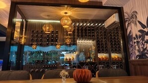 Un restaurant doté d’un bar à vin, d’un éclairage suspendu et offrant une vue sur la ville.