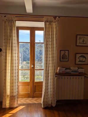 Ein Zimmer mit Holztür, Heizkörper und einem Bücherregal.
