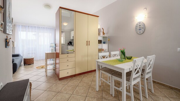 Eine moderne Küche mit Essbereich, einem großen Schrank und einer Wanduhr.