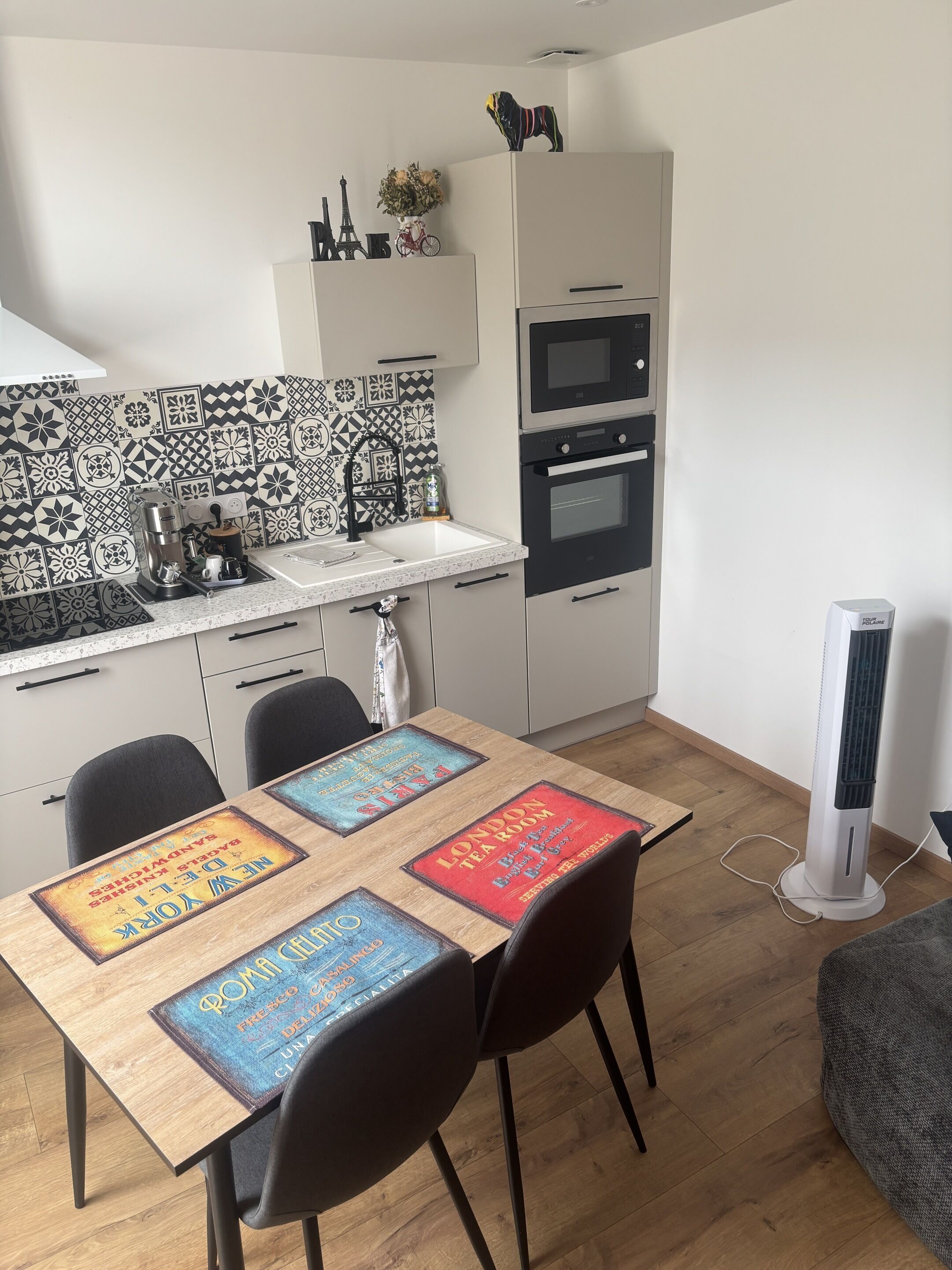 A compact kitchen with a coffee machine, a sink, and a microwave.