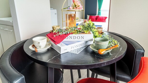 Ein runder Tisch mit einem Buch mit dem Titel 'LONDON FONDEST', einer weißen Tasse, einem Untertasse und einem Holzlöffel.