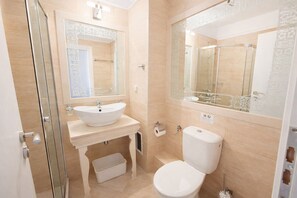A bathroom with a white sink, toilet, and glass shower enclosure. - Harmony Suites-4 Private Apartment B544 (Слънчев бряг)