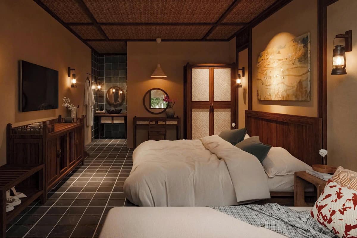 Una camera da letto tradizionale in stile giapponese, con un letto grande, un tavolino e una TV a parete.