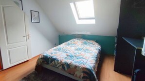 A bedroom with a bed, a window, a door, and a partial view of a wardrobe. - L écrin de l aube  (Grainville-la-Teinturière)