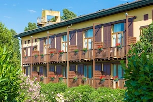 Un edificio a più piani con balconi, ognuno decorato con vasi di piante e fiori.