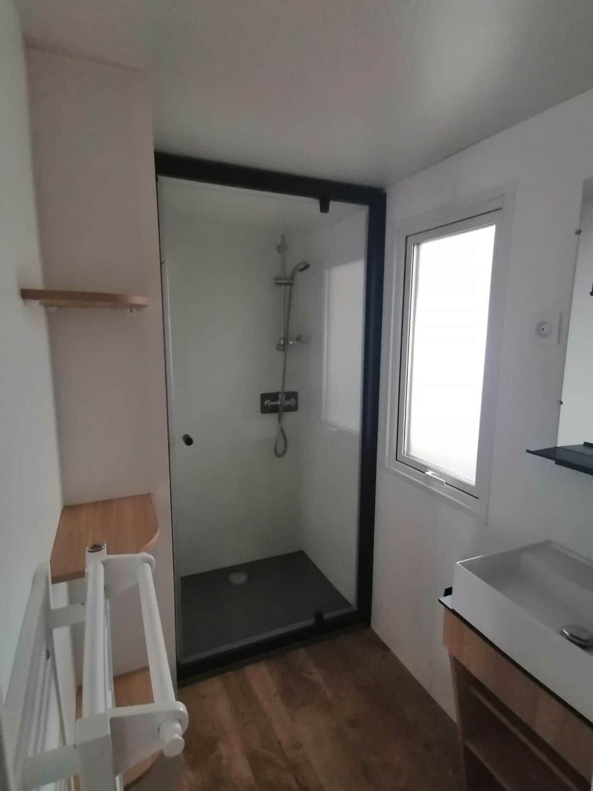 Un baño con ducha, lavabo y ventana.