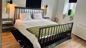 A bedroom with a bed, bedside tables, a window, and a view of the outdoors. - Chic Vintage Apartment in Spa (Spa)