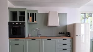 Eine Küche mit Einbauofen, Spüle und einem weißen Kühlschrank.