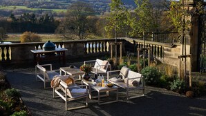 An outdoor seating area with a view of the countryside.