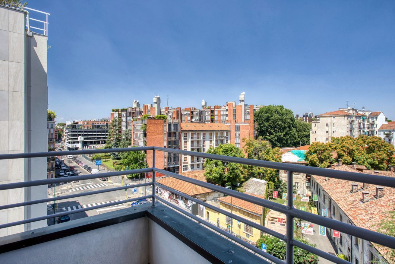 Ein Balkon mit Blick auf eine Stadtansicht, einschließlich Gebäude und einer Straße.