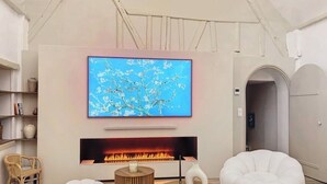 Una sala de estar moderna con chimenea, televisor montado y asientos cómodos.