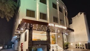 L’entrée d’un hôtel, avec une enseigne indiquant « HÔTEL SIDDHARTH GRAND », un espace d’entrée abrité et un escalier menant au hall d’accueil.