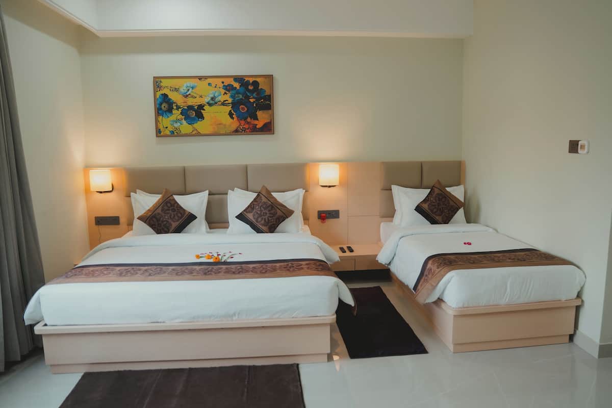 A double room with two beds, each with a headboard, bedside lamps, and decorative pillows.
