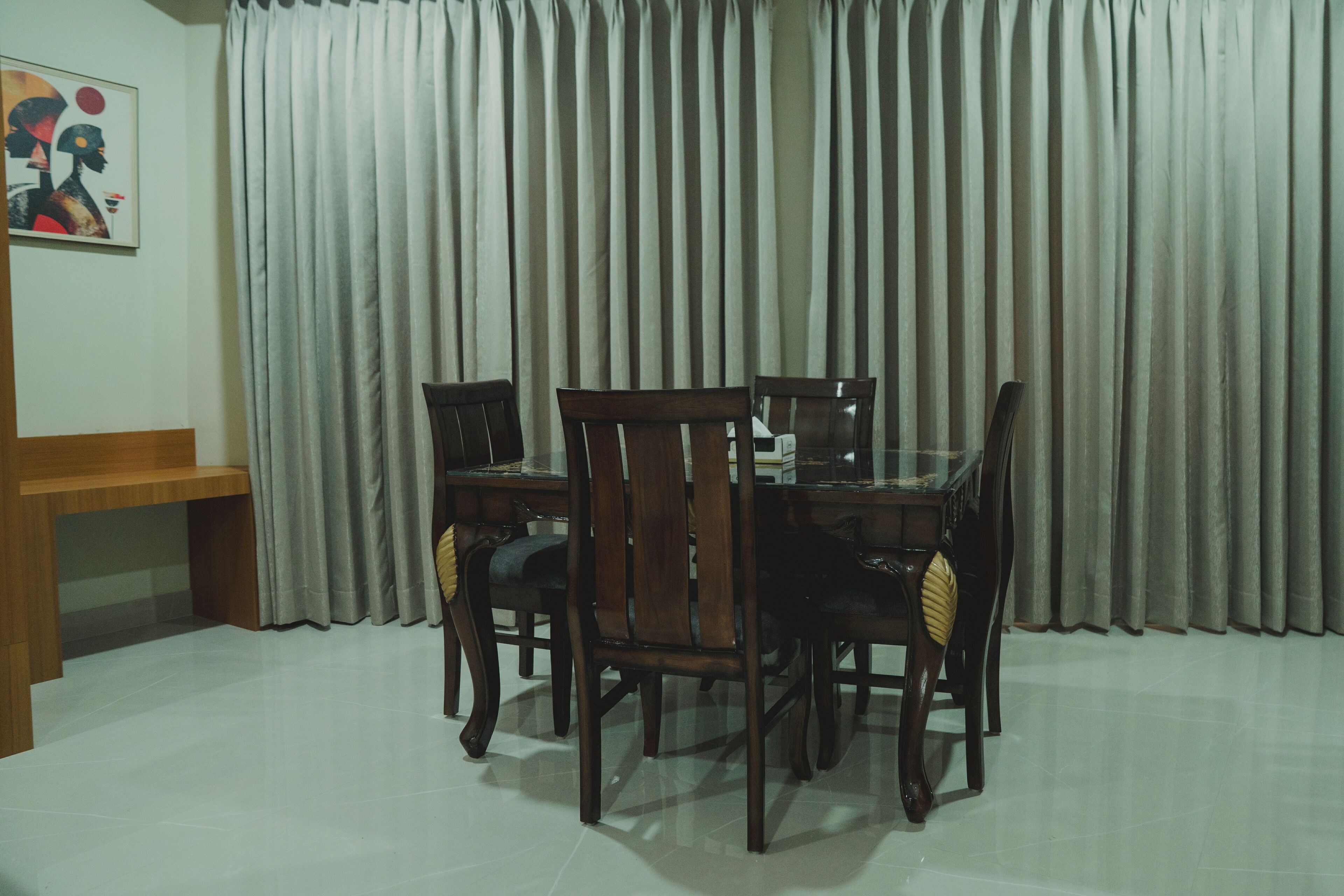 Un comedor con una mesa y sillas de madera, un banco y un cuadro en la pared.