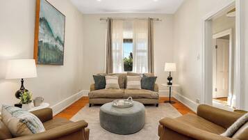 A living room with a sofa set, a coffee table, and two lamps.