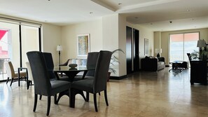 A spacious living area with a dining table, chairs, and a sofa. - Lux 2-BR 1 story Condo in the heart of Everything!!! (San Rafael de Escazú)