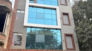 A modern building with large windows, a wooden facade, and a glass entrance. - Hotel Ramya (Varanasi)