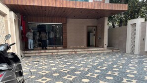 A modern building entrance with a patterned tile floor and a parked scooter. - Hotel Ramya (Varanasi)