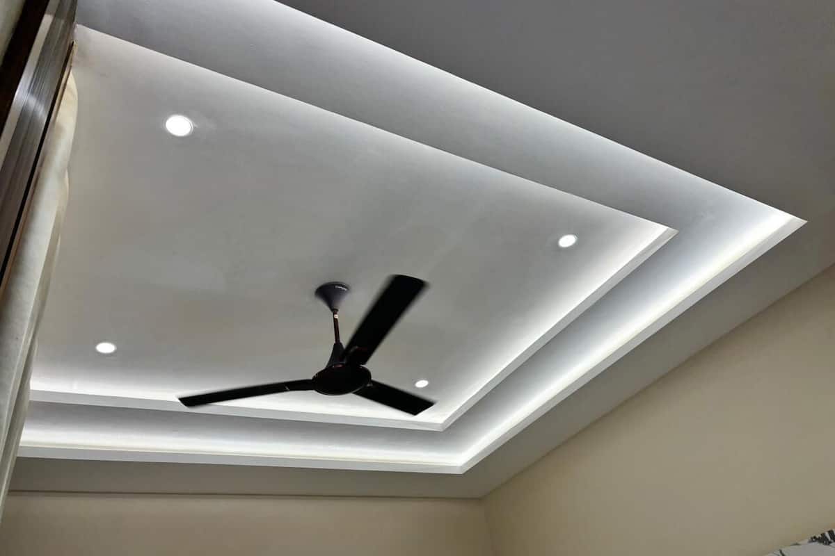 A ceiling with recessed lighting and a ceiling fan.