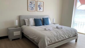 A bedroom with a bed, nightstands, and artwork on the wall. - Gorgeous 3-BR Condo in the heart of everything! (San Rafael de Escazú)