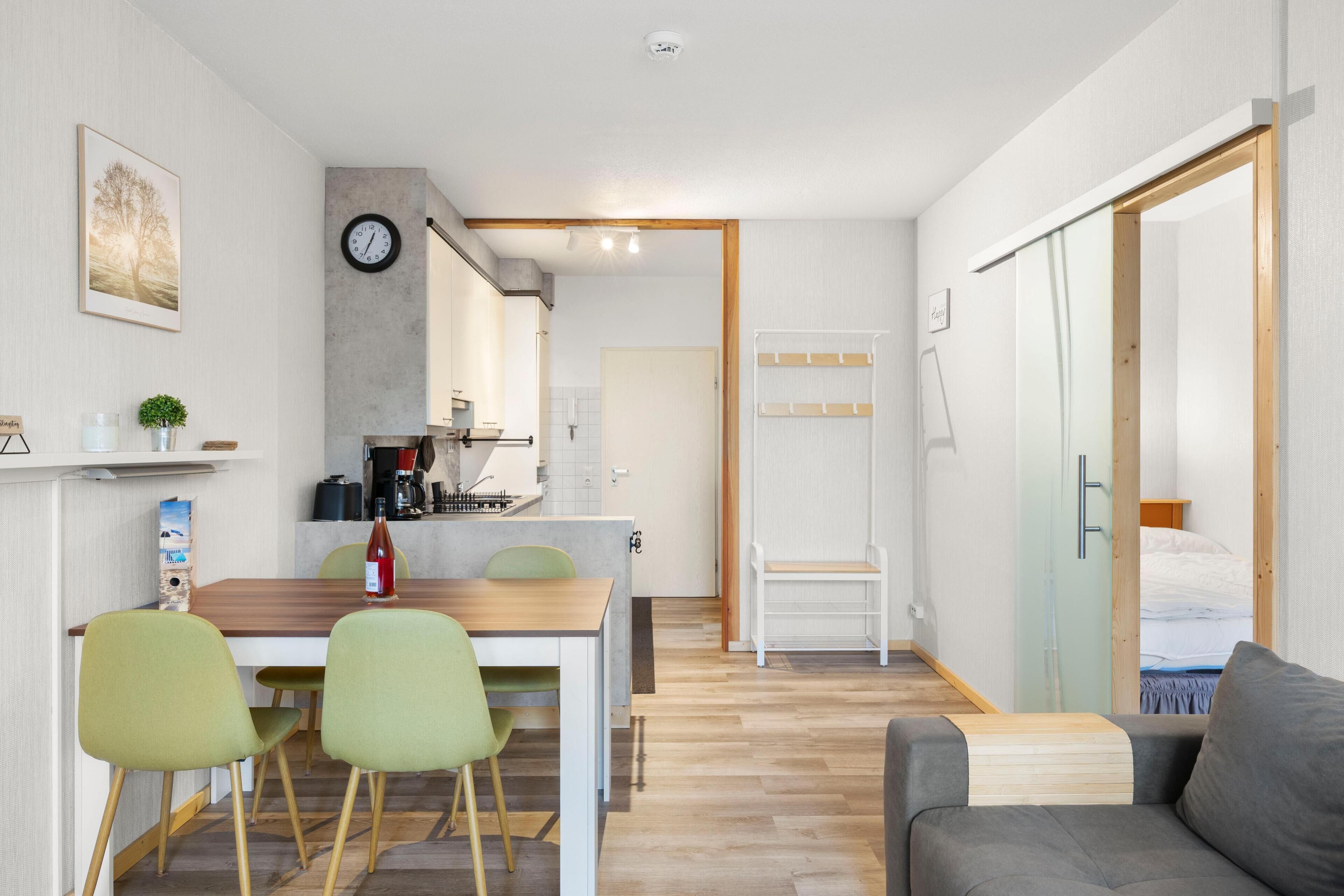 Eine moderne Küche mit Essbereich, einem Sofa und einem angrenzenden Schlafzimmer.