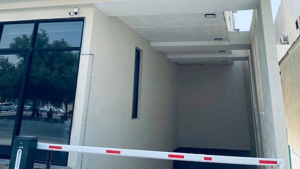 Un edificio con un letrero que dice "PARKING" y texto en árabe.
