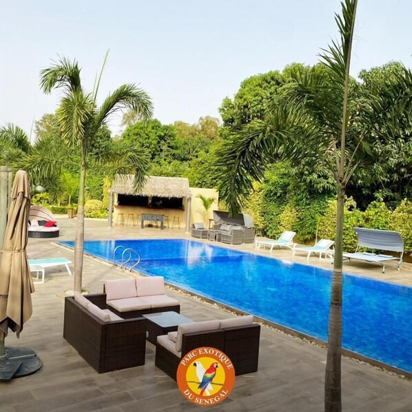 Una piscina al aire libre, camas de piscina gratis, sombrillas