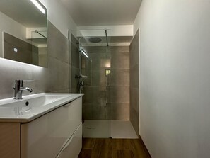 A modern bathroom with a glass shower enclosure, a white sink, and a large mirror. - Spacious villa for 10 guests - Park - Wi-Fi, Air Conditioning (La Palmyre)